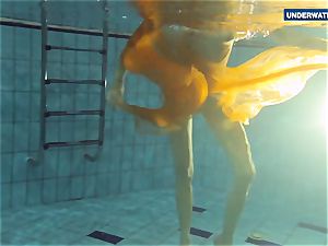 Yellow and red clothed nubile underwater